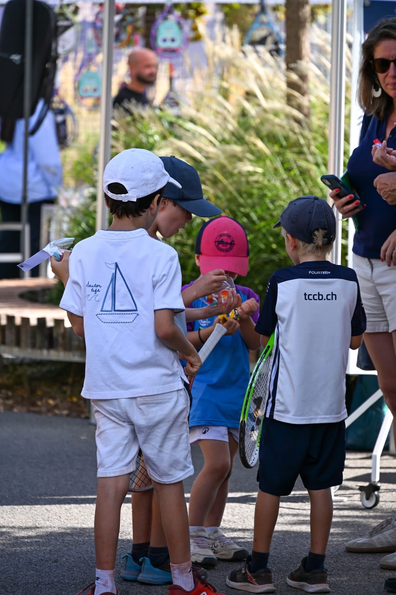 Des enfants en tenue de tennis discutent entre deux activités