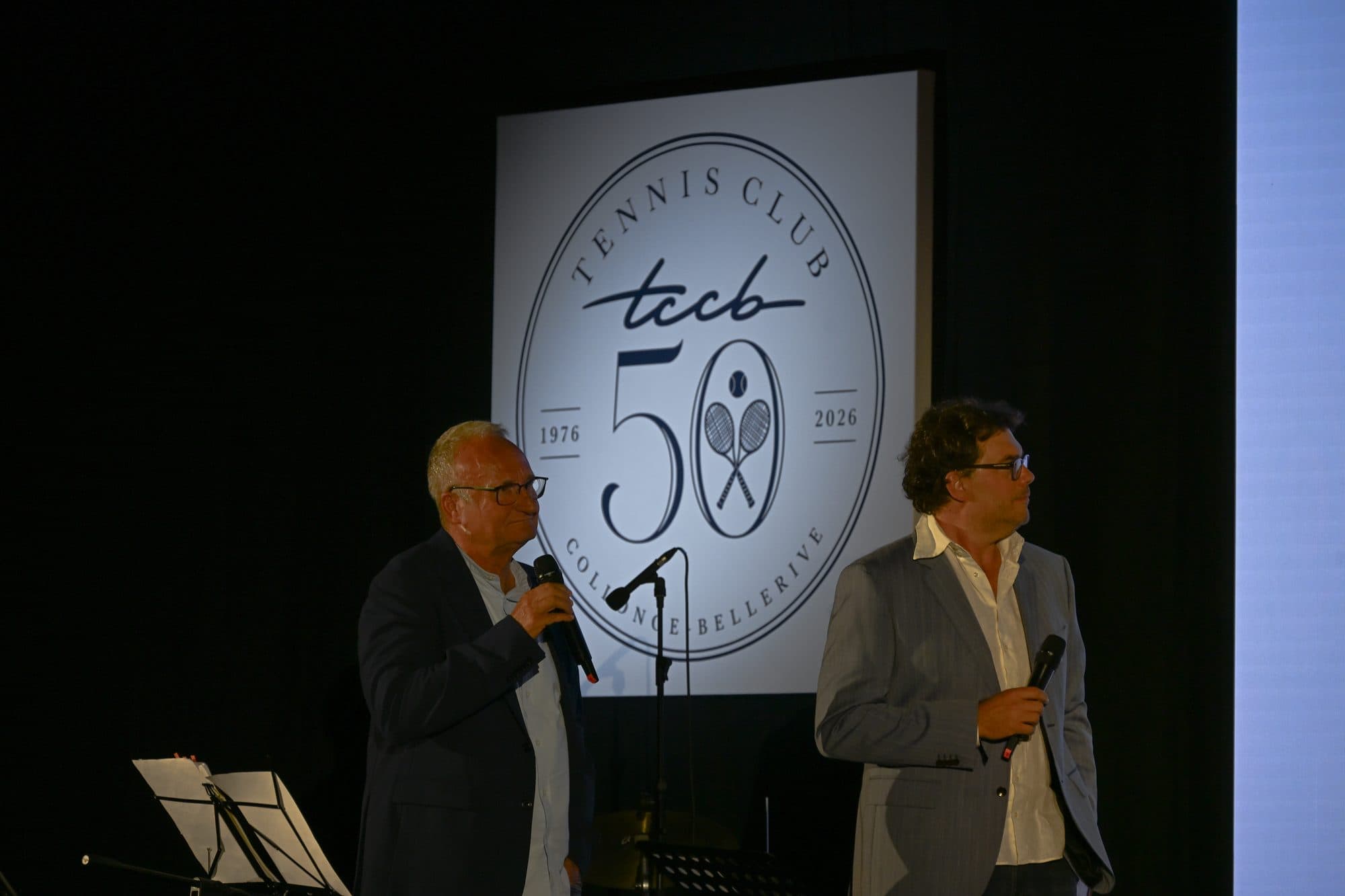 Deux anciens responsables du club interviewés sur scène devant le logo des 50 ans