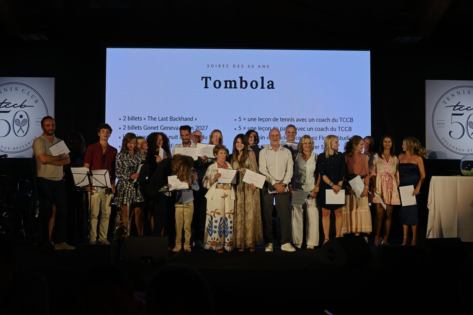 Les gagnants de la tombola réunis sur scène devant l’écran des lots