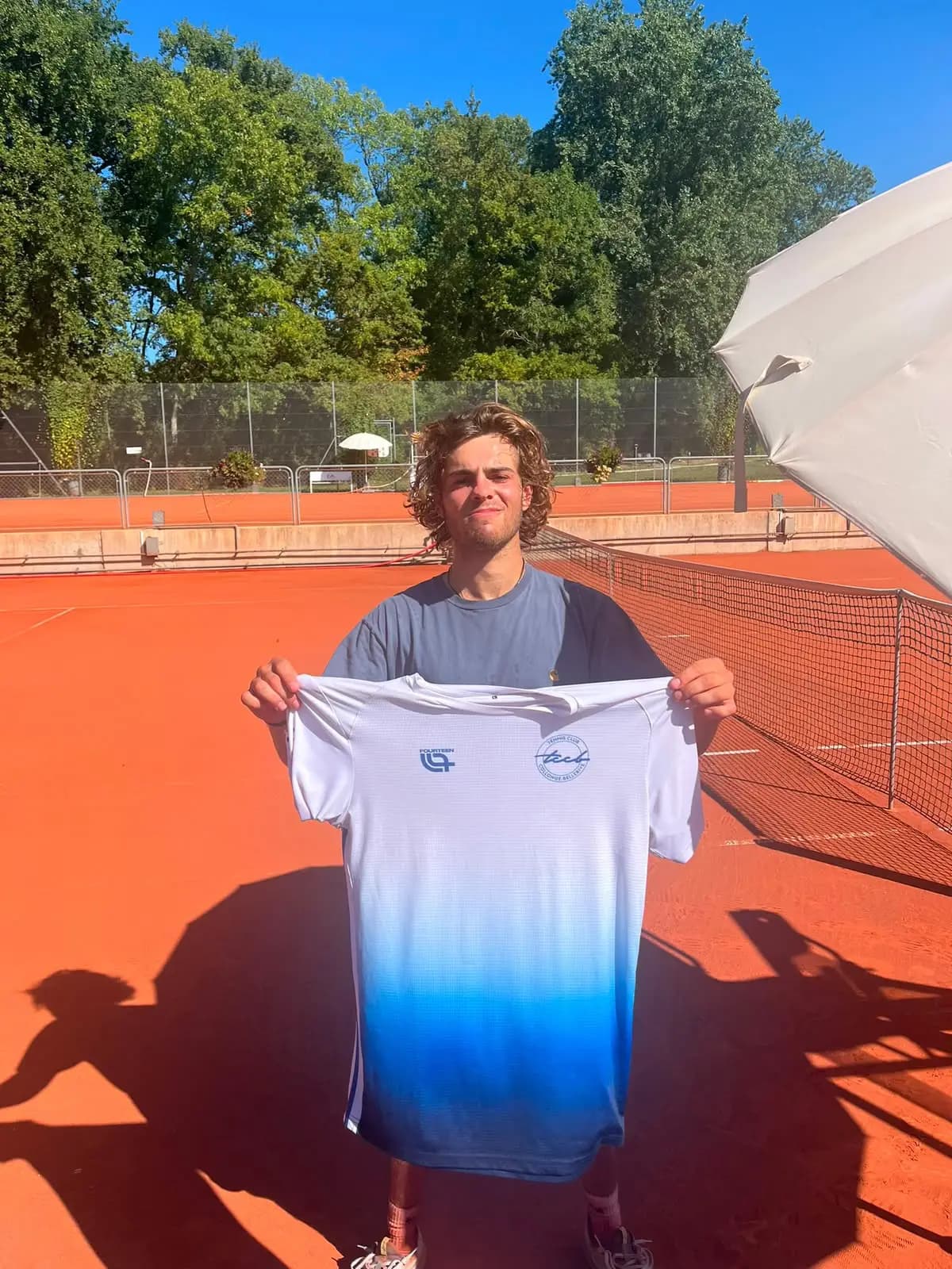 Oscar, a TCCB player, holding the club shirt on court