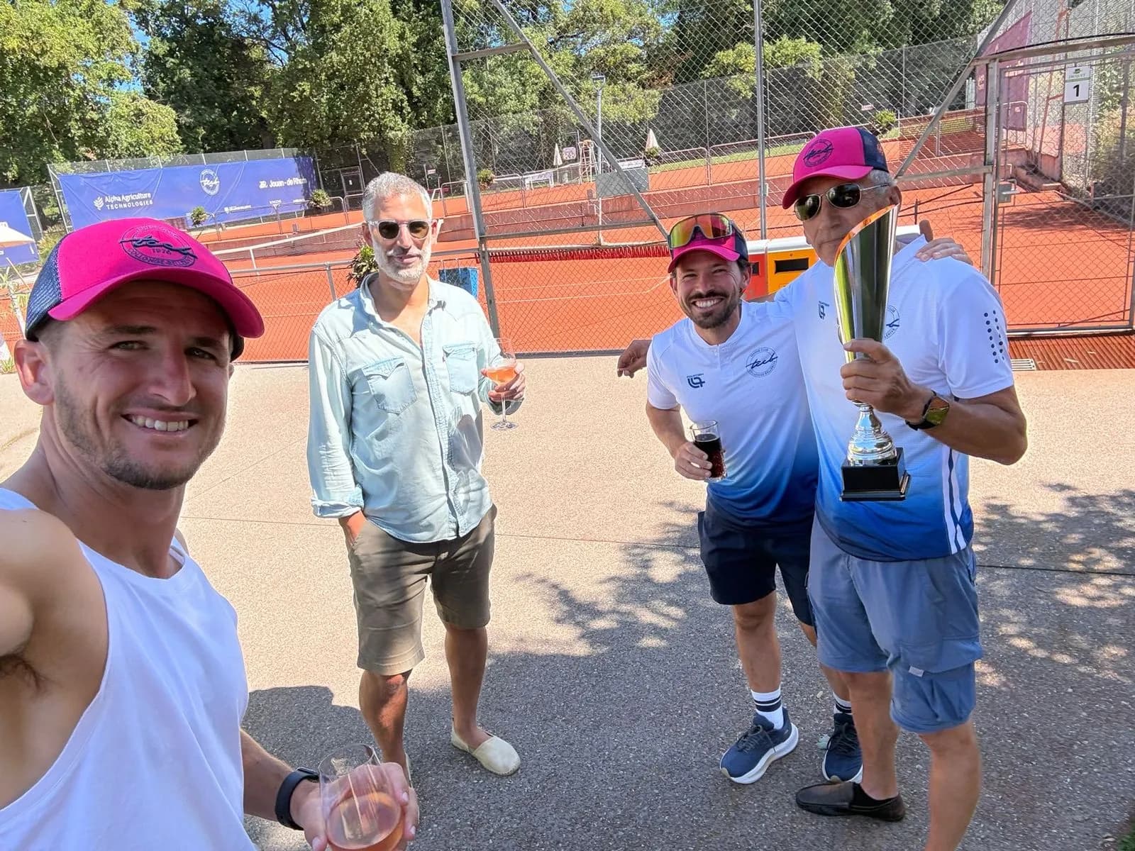 Joueurs du TCCB Open célébrant avec un trophée au bord des courts